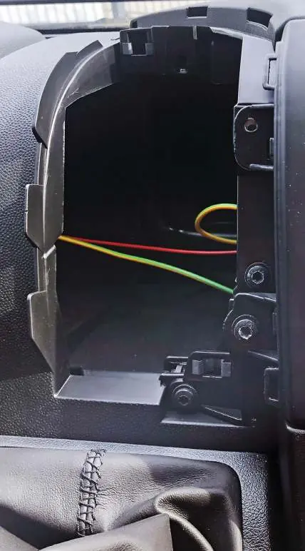 Removing the OEM storage compartment screws.