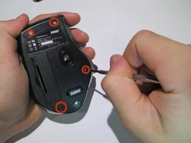 Removing the four screws from the bottom of the mouse.