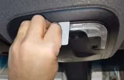 Removing the overhead console using a plastic card.