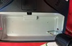 Marking screw holes in the sunglass holder cavity.