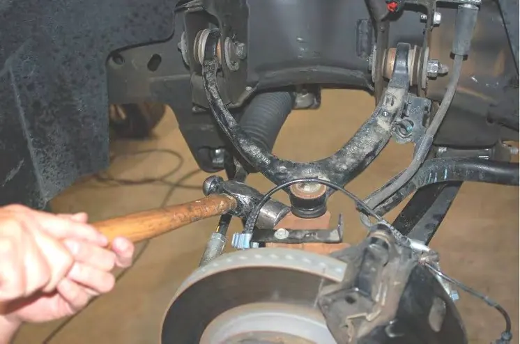 Striking the knuckle to dislodge the tie rod end.