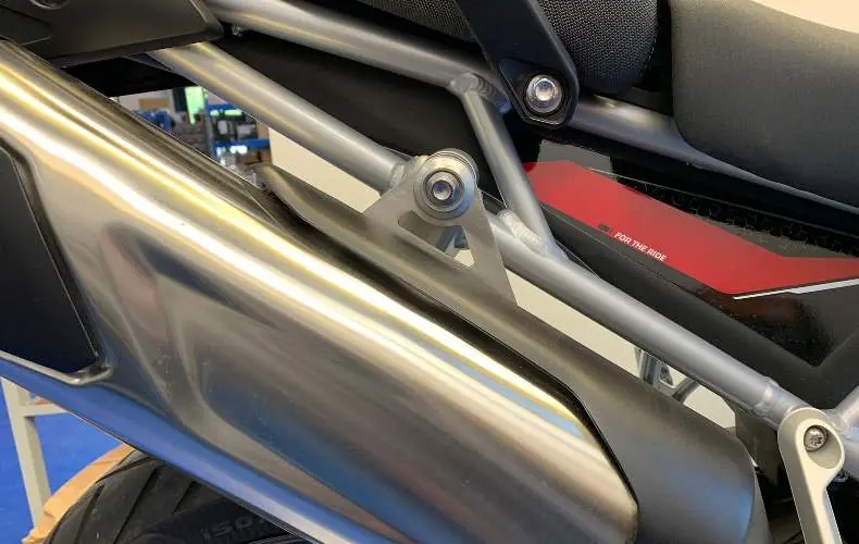 Secure the exhaust muffler to the motorcycle frame bracket.