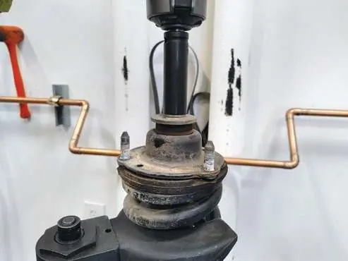 Compress the coil spring.