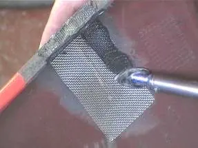 Melting the stainless steel mesh into the plastic using the soldering iron.