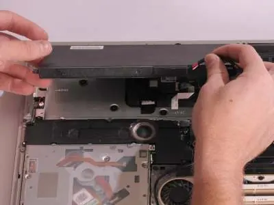 Removing the battery from the laptop.