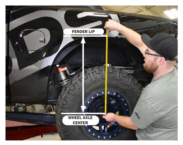 Correct method for measuring ride height from wheel axle center to fender lip.