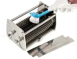 Cleaning the blade assembly with a brush.